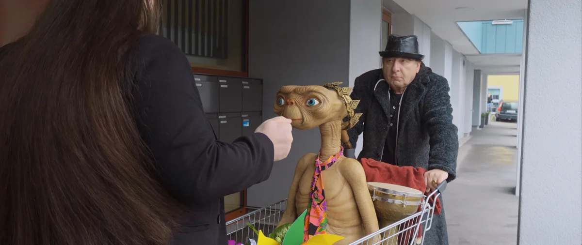 Beat Schlatter und E.T. in einer Aussenszene vor der Bar My Senses in Dübendorf. Szene aus dem Film «Do Re Mi Fa So lauft’s».